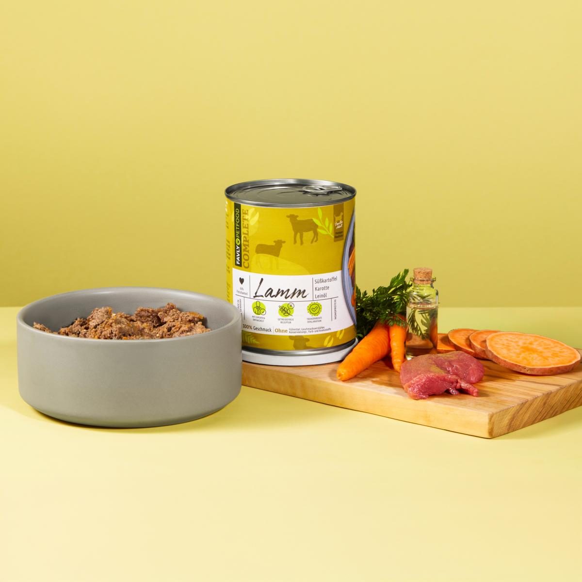 FAVLY Petfood's Lamm mit Süßkartoffel & Karotte Nassfutter auf einem Brett mit Schüssel, vor gelbem Hintergrund.
