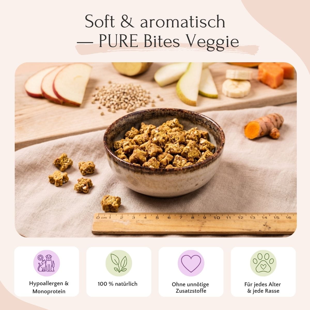 PURE Bites Veggie von FAVLY Petfood, abgebildet mit einem Lineal, umgeben von frischem Apfel, Karotte und Kurkuma.