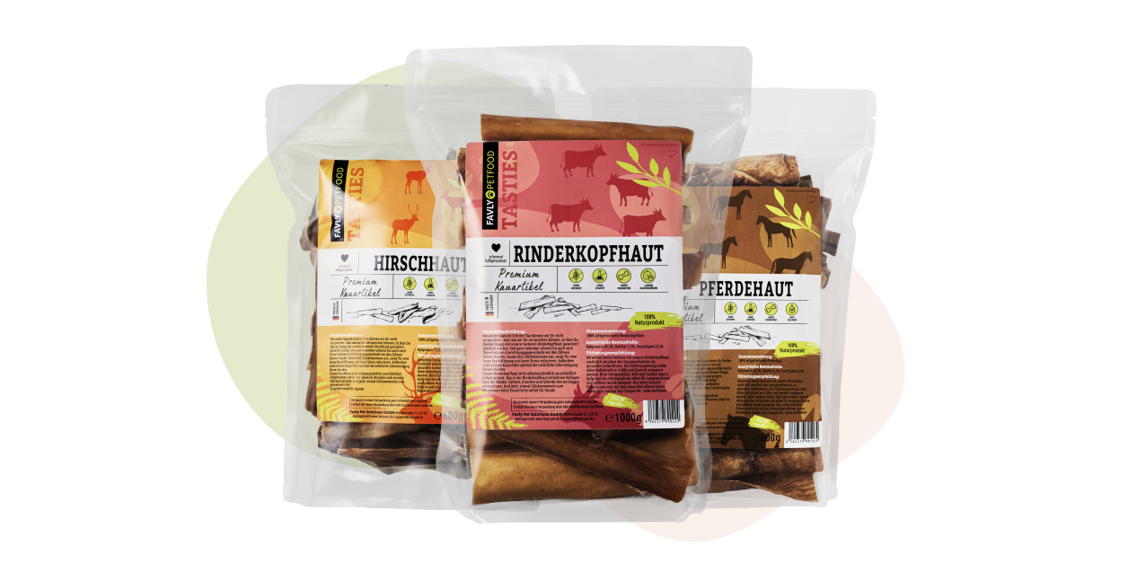 Drei Packungen Kausnacks für Haustiere mit den Aufschriften „Hirschhaut“, „Rinderkopfhaut“ und „Pferdehaut“ mit Tierillustrationen.