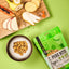Schale mit Veggie-Snacks, geschnittenem Obst und FAVLY Petfood PURE Bites Veggie auf grünem Hintergrund.